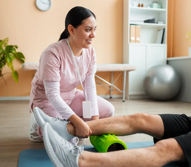 Physiotherapist helping a patient with rehabilitation at home